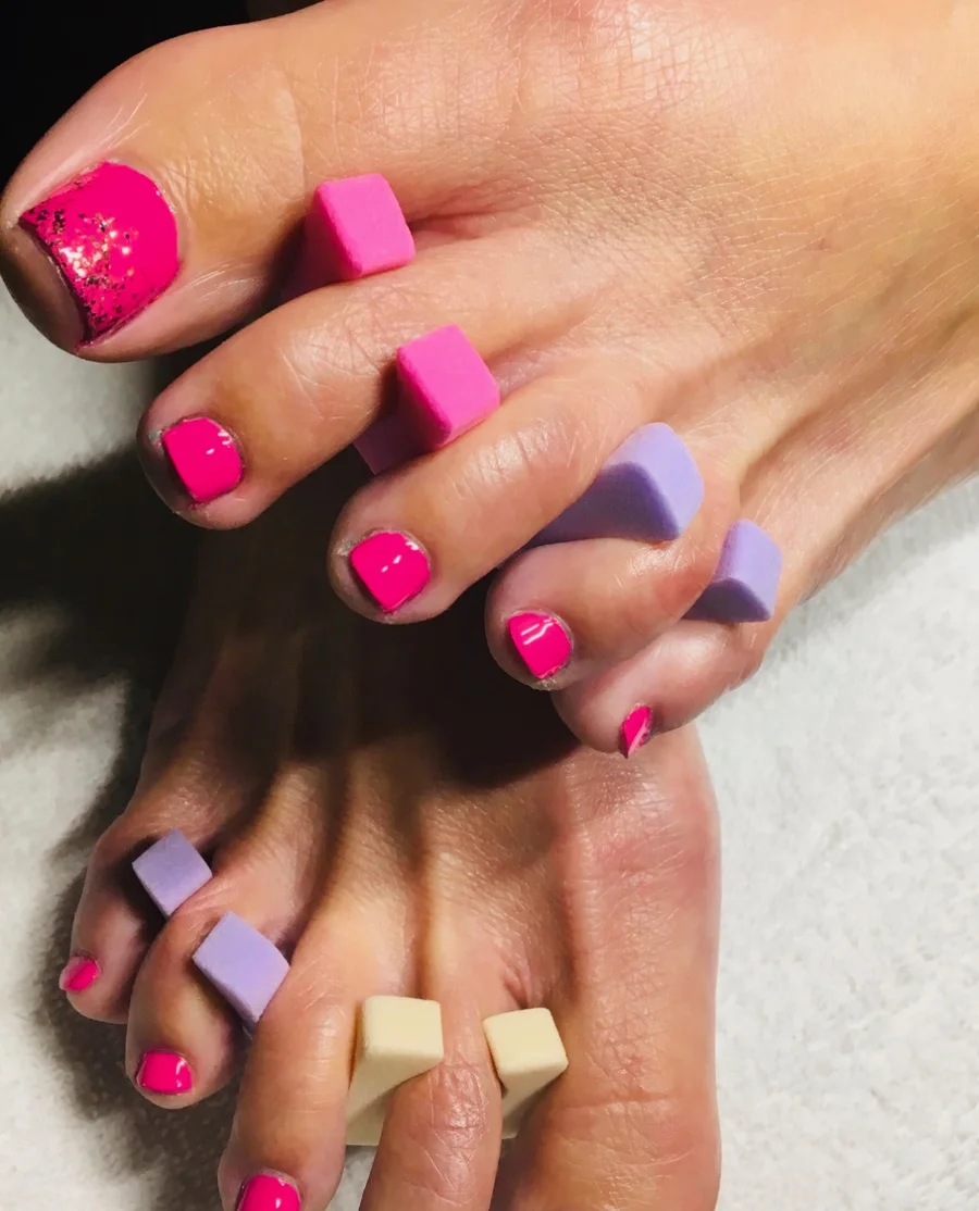 Hot pink pedicure with glitter accents and toe separators