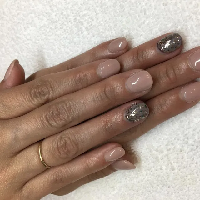 Spa manicure with nude polish and glitter accents